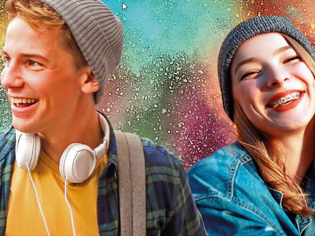 Two smiling teenagers, one is wearing headphones