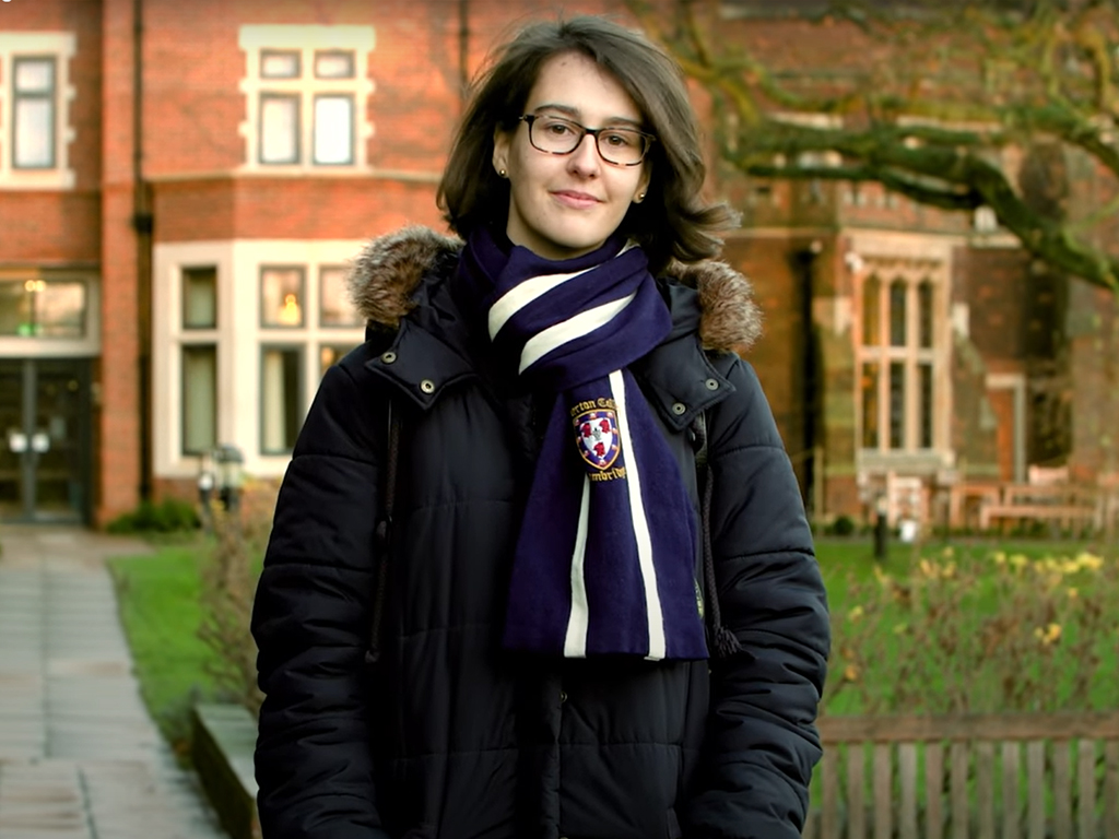 A student wearing a scarf with a school crest on it